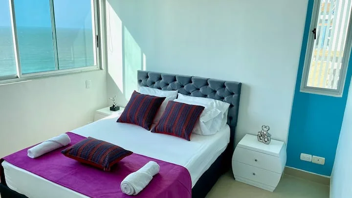 Dormitorio con cama y ventanales frente al mar — Palmetto 1001