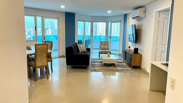 Sala y comedor con ventanales y acceso al balcón — Torres del Lago 1303